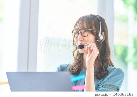 眼鏡をかけて考えながら通話する女性オペレーター 眼鏡をかけて考えながら通話する女性オペレーター 140365168