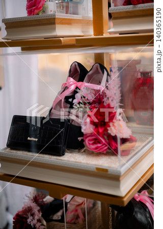 A luxurious wedding gift display featuring elegant high heels, handbags, and flower arrangements. 140365190