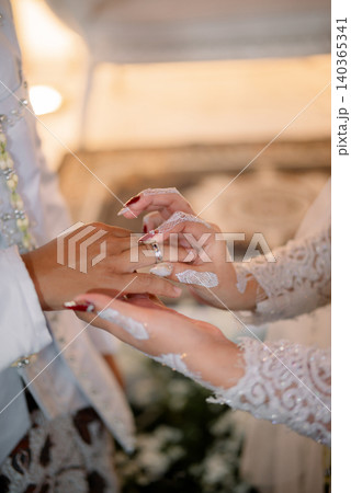 The wedding ring exchange ceremony in a traditional Javanese wedding celebration. The wedding ring exchange ceremony in a traditional Javanese wedding celebration. 140365341
