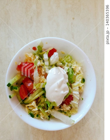 Fresh Vegetable Salad with Lettuce, Tomato, Cucumber, Egg and Creamy Sauce in White Bowl Top View Healthy Meal 140365396