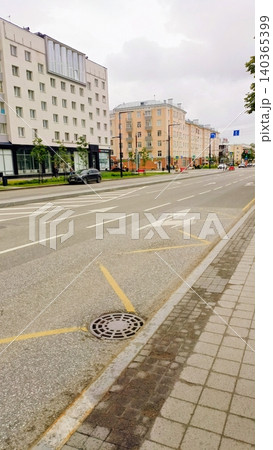 Wide Urban Street with Asphalt Road, Sidewalk, and Modern Residential Buildings under Cloudy Sky Wide Urban Street with Asphalt Road, Sidewalk, and Modern Residential Buildings under Cloudy Sky 140365399