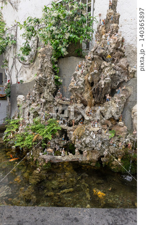 A historic stone Fontana di Cape 'e Ciuccio Fountain of the Donkey's Head in Amalfi, Italy. This unique 18th-century fountain with numerous small figures. 140365897