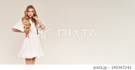 Blonde young woman in elegant white dress Blonde young woman in elegant white dress 140367242