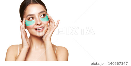 Young woman with cosmetic patches on her eyes Young woman with cosmetic patches on her eyes 140367347