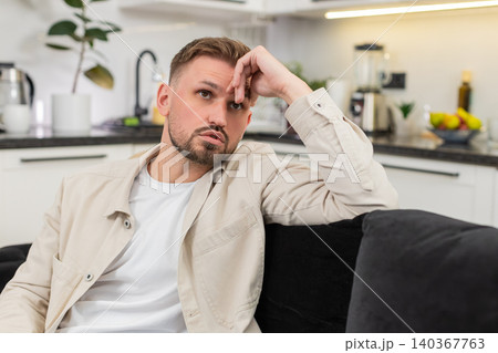 Young man after tough day shows tired mood silent stare and long sigh after many issues and stress Young man after tough day shows tired mood silent stare and long sigh after many issues and stress 140367763