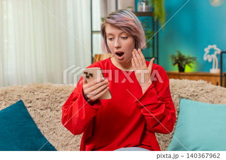 Woman surprised by unexpected money transfer on smartphone, shocked happy facial expression reaction Woman surprised by unexpected money transfer on smartphone, shocked happy facial expression reaction 140367962