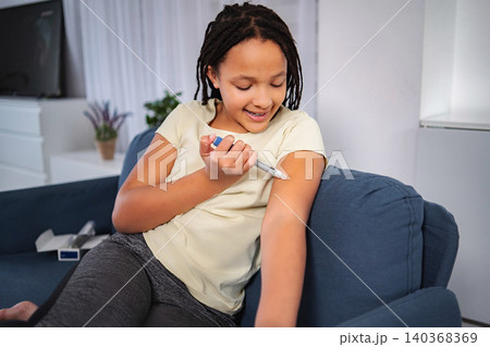 Young girl smiling injecting insulin for diabetes management Young girl smiling injecting insulin for diabetes management 140368369