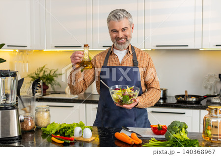 Middle-aged man presenting vegetable salad bowl in home kitchen for healthy diet meal prep guide pro 140368967