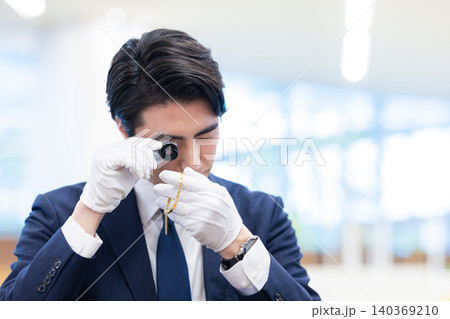 出張買取　貴金属の査定をしている男性　撮影協力：学校法人電波学園　東京電子専門学校 140369210