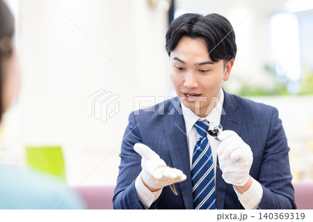 出張買取　貴金属の査定をしている男性　撮影協力：学校法人電波学園　東京電子専門学校 140369319