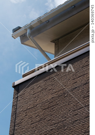 強い日差しや夏に2階建ての住宅のベランダの外壁が色褪せている状況。外壁の劣化、色褪せ 強い日差しや夏に2階建ての住宅のベランダの外壁が色褪せている状況。外壁の劣化、色褪せ 140369745