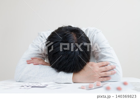 中年男性の体調不良、病気と大量の薬。悩む男性は複数の薬を試している 中年男性の体調不良、病気と大量の薬。悩む男性は複数の薬を試している 140369823