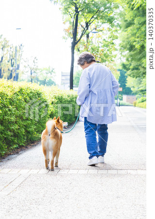 ペット　柴犬とお散歩しているシニア女性 140370335