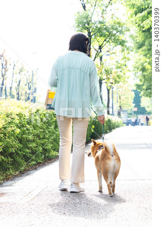 ペット　柴犬とお散歩している女性も後ろ姿 140370399