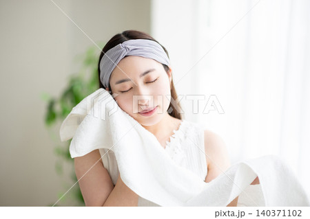 タオルで顔を拭く女性 140371102