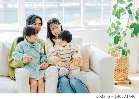 明るいリビングでくつろぐ家族 明るいリビングでくつろぐ家族 140371446