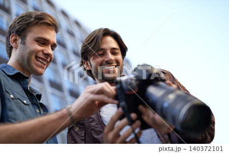 Men, friends and photographer with digital camera in urban, streets and town with media for portfolio in London. Collaboration, creativity and photography in city to build profile for project. 140372101