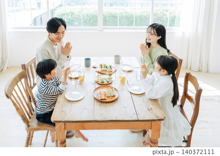 食事をする前に手を合わせる家族 食事をする前に手を合わせる家族 140372111