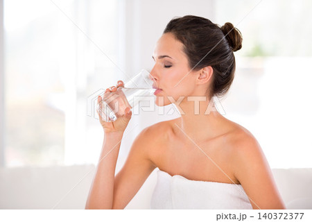 Home, woman and skincare with drinking water in towel for routine, treatment and body care in living room. Female person, hydration and smooth with cosmetic for natural glow, soft and confidence. Home, woman and skincare with drinking water in towel for routine, treatment and body care in living room. Female person, hydration and smooth with cosmetic for natural glow, soft and confidence. 140372377