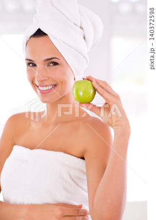 Happy woman, portrait and beauty with apple for nutrition, diet or healthy vitamins at home. Face of young female person or model with smile and organic green fruit for natural skincare or wellness Happy woman, portrait and beauty with apple for nutrition, diet or healthy vitamins at home. Face of young female person or model with smile and organic green fruit for natural skincare or wellness 140372598
