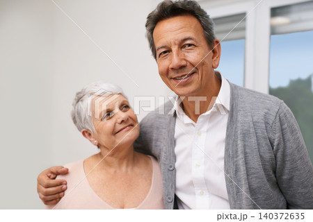 Portrait, senior or happy couple hug in lounge at home for bonding together with support, pride or smile. Retirement, people or romantic man by an elderly woman for peace, love or care in marriage 140372635