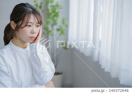 窓際で悩む女性 窓際で悩む女性 140372646