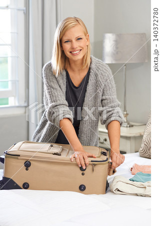 Portrait, smile and woman packing a suitcase for travel, vacation or ready for holiday. Face, happy person and luggage in bedroom for trip preparation, journey or tourism with clothes in bag at home 140372780
