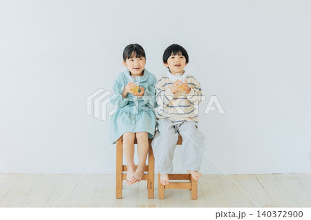 椅子に座ってジュースを飲む子ども 椅子に座ってジュースを飲む子ども 140372900
