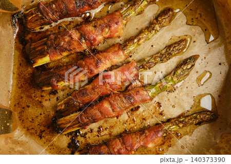 Bacon wrapped asparagus cooked on parchment in kitchen 140373390