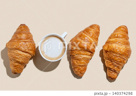 Cup of cappuccino coffee and croissants on a yellow isolated background Cup of cappuccino coffee and croissants on a yellow isolated background 140374298