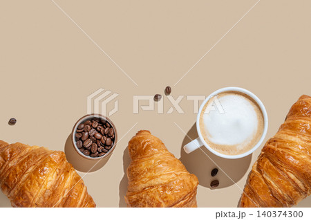 Cup of cappuccino, coffee beans and croissants on a yellow isolated background Cup of cappuccino, coffee beans and croissants on a yellow isolated background 140374300