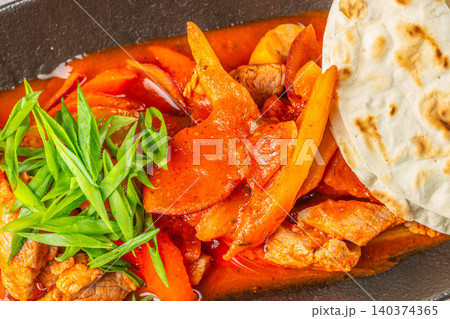 Spicy Meat Stir Fry with Bell Peppers and Flatbread Closeup 140374365