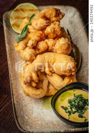 Crispy fried calamari rings with creamy dipping sauce in restaurant style presentation Crispy fried calamari rings with creamy dipping sauce in restaurant style presentation 140374492