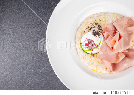 Savory oatmeal with poached egg and mortadella on white plate with copy space top view Savory oatmeal with poached egg and mortadella on white plate with copy space top view 140374519