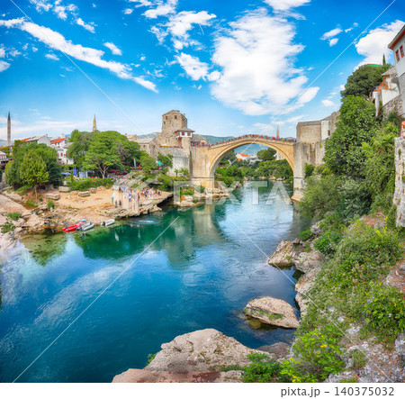 Amazing Skyline of Mostar with the Mostar Bridge, houses and minarets, during sunny day Amazing Skyline of Mostar with the Mostar Bridge, houses and minarets, during sunny day 140375032
