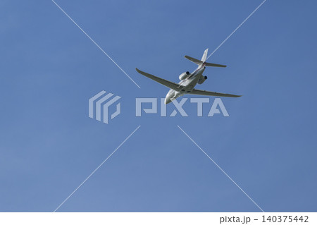 Private jet airplane flying high in blue sky over Hostivice Private jet airplane flying high in blue sky over Hostivice 140375442