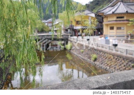 風情ある城崎温泉街を流れる川と手前に佇むしだれ柳の情緒豊かな風景 風情ある城崎温泉街を流れる川と手前に佇むしだれ柳の情緒豊かな風景 140375457