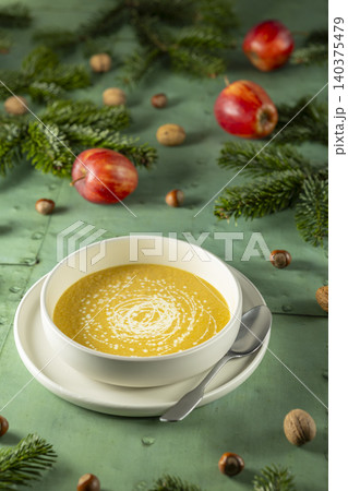 Creamy pumpkin soup on a rustic Christmas table setting Creamy pumpkin soup on a rustic Christmas table setting 140375479