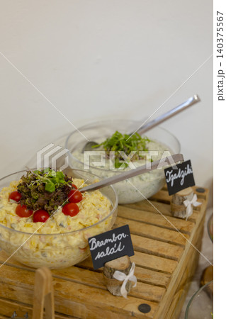 Potato salad and tzatziki bowls on buffet table Potato salad and tzatziki bowls on buffet table 140375567