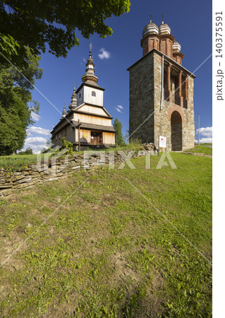 Historic wooden church and belfry with stone wall in Poland 140375591