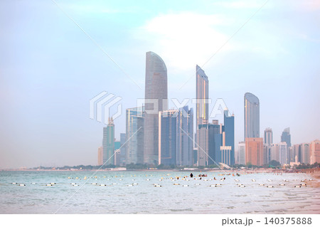 City skyline and beach visitors enjoying a sunny day by the coast of a modern urban area 140375888