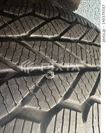 自動車タイヤに刺さった金属ネジ パンクトラブルのイメージ 140376587