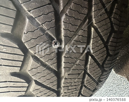 ネジが刺さった自動車タイヤ パンク原因のクローズアップ写真 140376588