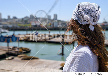 Woman looking at sea lions near Pier 39 marina in San Francisco 140376622