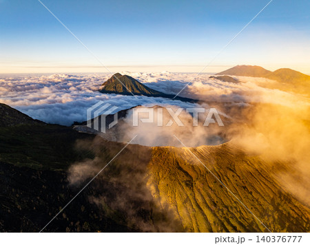 Aerial view of rock cliff at Kawah Ijen volcano with turquoise sulfur water lake at sunrise.Amazing nature landscape view at East Java, Indonesia. Natural landscape background 140376777