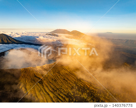 Aerial view of rock cliff at Kawah Ijen volcano with turquoise sulfur water lake at sunrise.Amazing nature landscape view at East Java, Indonesia. Natural landscape background Aerial view of rock cliff at Kawah Ijen volcano with turquoise sulfur water lake at sunrise.Amazing nature landscape view at East Java, Indonesia. Natural landscape background 140376778