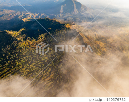 Aerial view of rock cliff at Kawah Ijen volcano with turquoise sulfur water lake at sunrise.Amazing nature landscape view at East Java, Indonesia. Natural landscape background 140376782