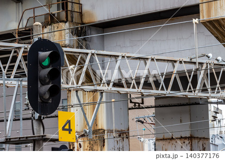 鉄道の信号機 青信号を現示する3灯式信号機と架線柱(ローアングル・インフライメージ) 鉄道の信号機 青信号を現示する3灯式信号機と架線柱(ローアングル・インフライメージ) 140377176