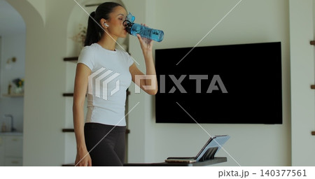Workout, woman and walking on treadmill in home for cardio exercise, fitness challenge and burning calories. Workout, woman and walking on treadmill in home for cardio exercise, fitness challenge and burning calories. 140377561