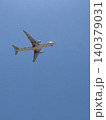 Commercial Passenger Airplane Viewed From Below Against Bright Blue Sky 140379031